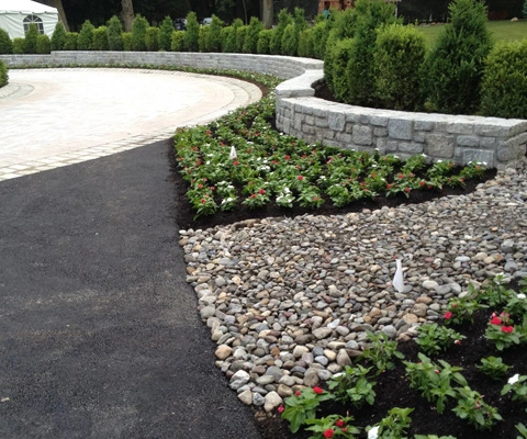 Seating wall installed beside landscape beds in New York.