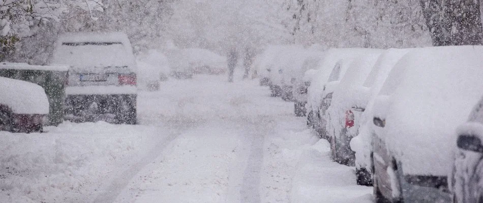 Cars on a road in Tarrytown, NY covered in snow.